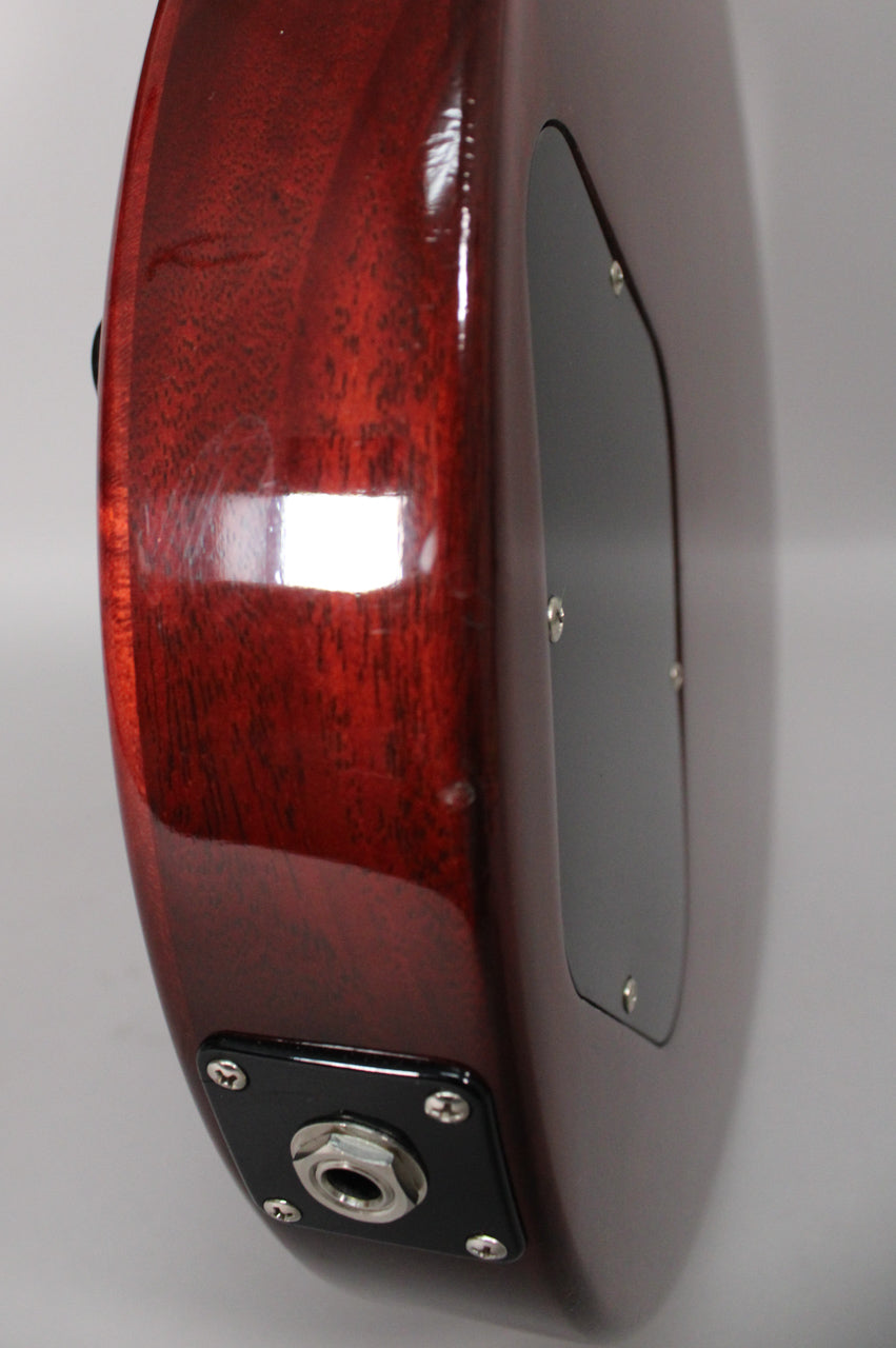 The guitar's dark cherry body, with visible wood grain and a glossy finish, shows minor surface scratches and a black output jack plate.
