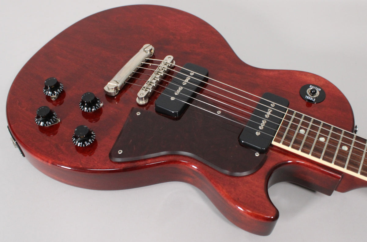Angled view of the dark cherry Les Paul Special's body, showing four black control knobs, two black P90 pickups, and a dark pickguard.
