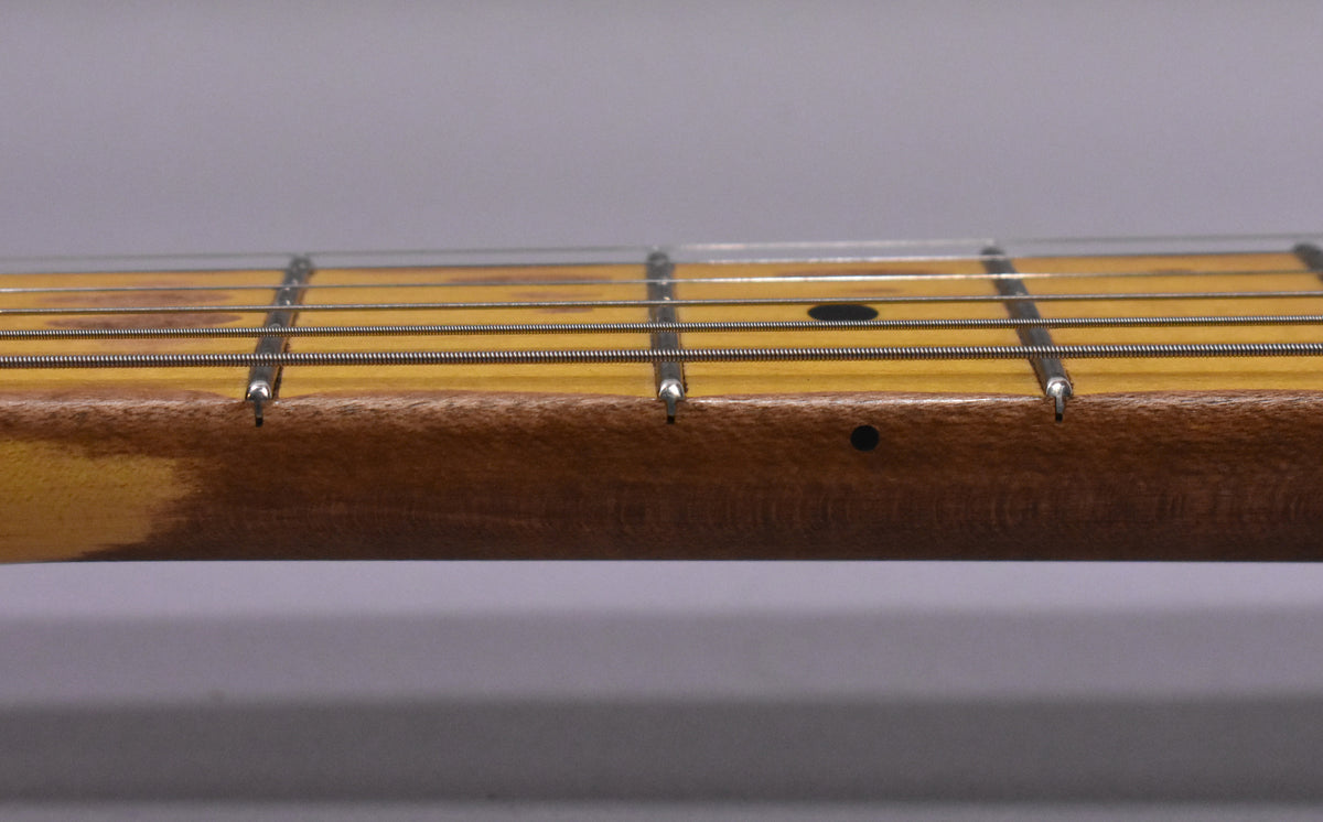 Close-up of the guitar's neck and fretboard, showing dark side dots, light relic wear on the maple fretboard, and dark wood on the neck.