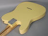 The back of a vintage white Telecaster body, showing the neck plate, string-through-body ferrules, and a light maple neck.
