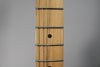 Close-up of the Telecaster's maple fretboard, showing five frets, six strings, and black dot inlays on the 7th and 9th frets.