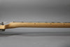 Side view of the light wood neck and fretboard, showing the first few frets and black dot inlays.