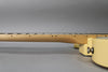 Side view of the guitar's maple neck and fretboard, showing black dot inlays and the vintage white body with a chrome strap button.