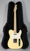 Full-length view of a vintage white Telecaster with a maple neck, white pickguard, and chrome hardware, resting in an open black hard case.