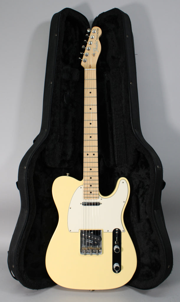 Full-length view of a vintage white Telecaster with a maple neck, white pickguard, and chrome hardware, resting in an open black hard case.