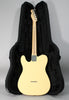 The back of a vintage white Telecaster with a maple neck, chrome tuners, and string-through-body ferrules, resting in a black hard case.