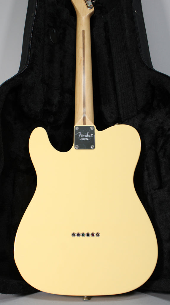 The back of a vintage white Telecaster, showing the light maple neck, chrome neck plate, and six string-through-body ferrules.