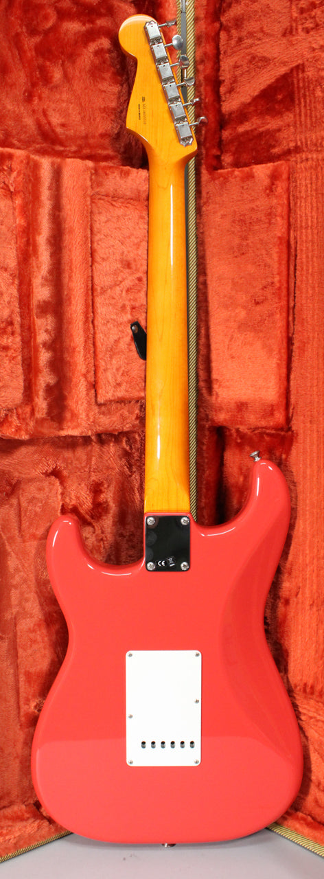 The back of a glossy Fiesta Red Stratocaster, showing the neck plate, white tremolo cover, and six chrome tuners on the headstock.