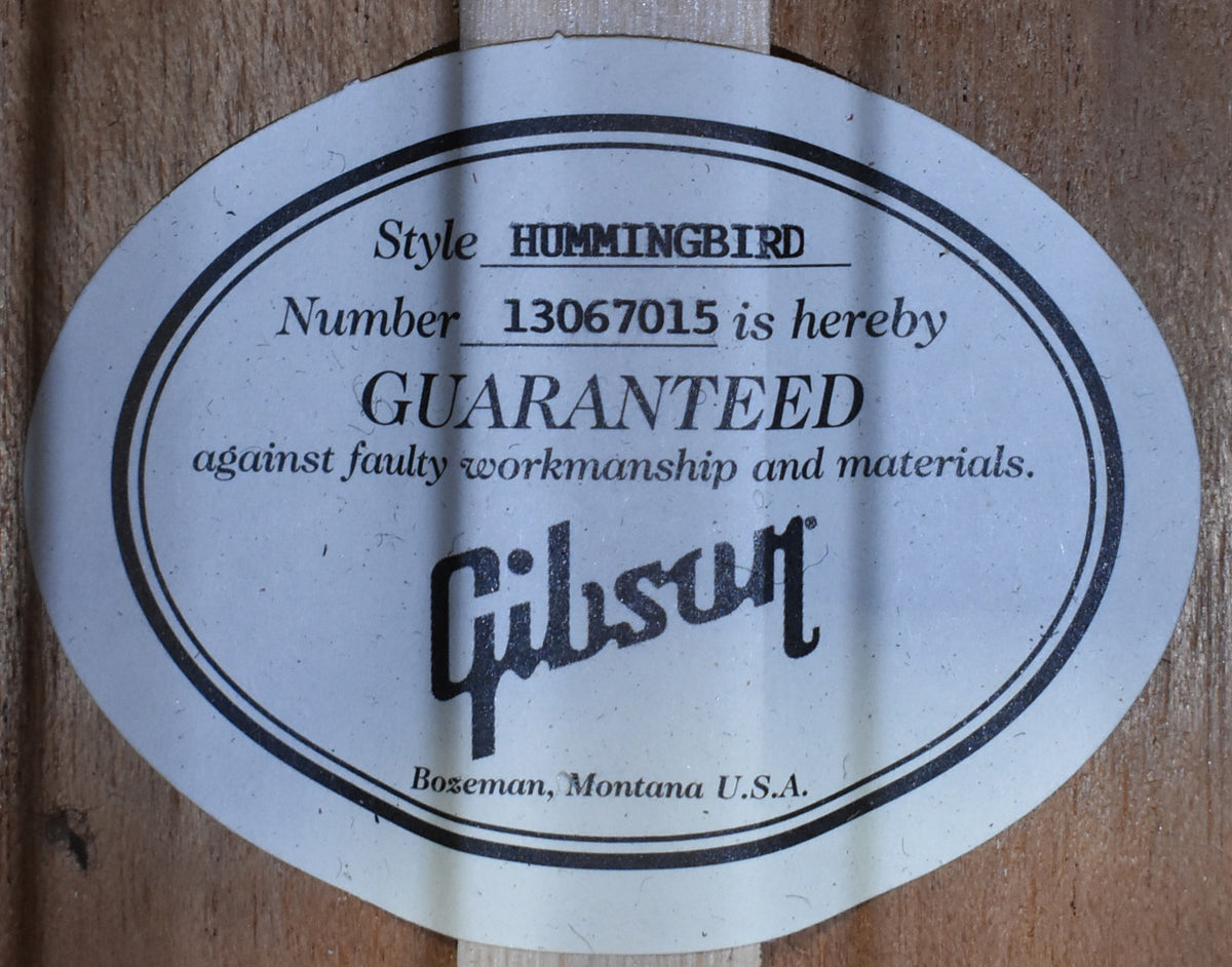 Close-up of the oval-shaped white paper label inside the soundhole, showing the serial number and "GUARANTEED" text.