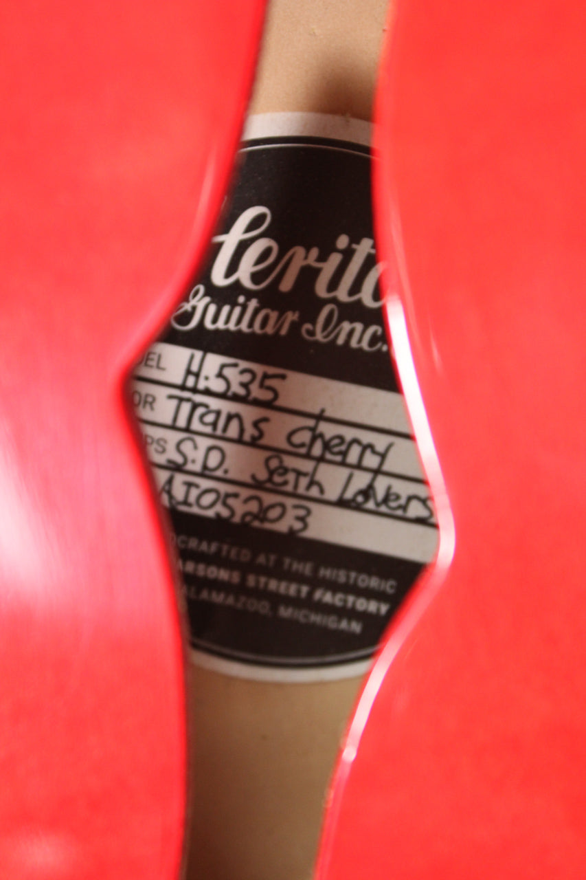 A close-up of the guitar's F-hole, revealing a black and white label with "H-535" and "Trans Cherry" handwritten on it.