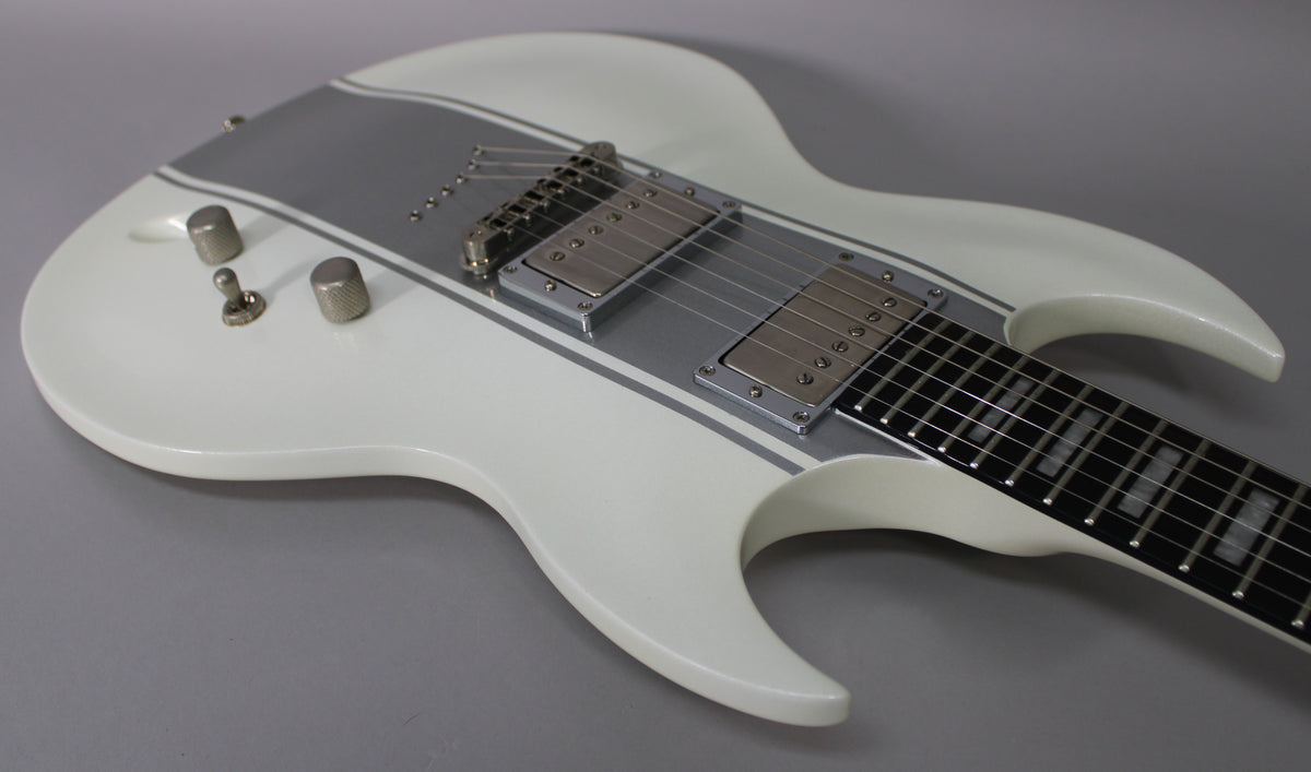 White double-cutaway electric guitar, angled from above, showing two humbuckers, two knurled chrome knobs, and a toggle switch.