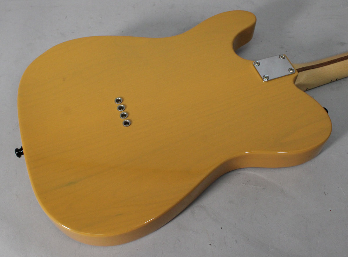 The back of a butterscotch blonde Telecaster body, showing a chrome neck plate, four string ferrules, and a black strap button.