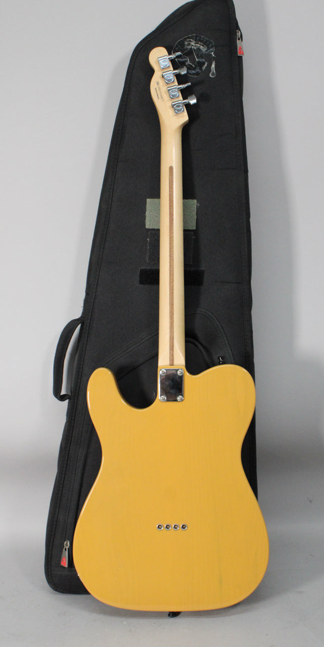 The butterscotch blonde Telecaster is shown from the back, revealing a light wood neck, chrome tuners, and four string ferrules.