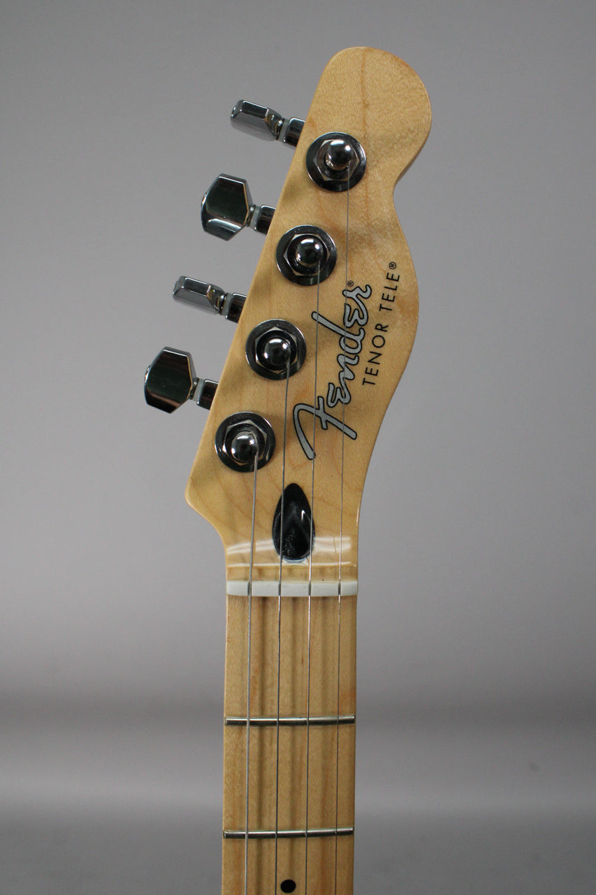 Close-up of the maple headstock and fretboard, showing four chrome tuners, a black string tree, and a white nut.