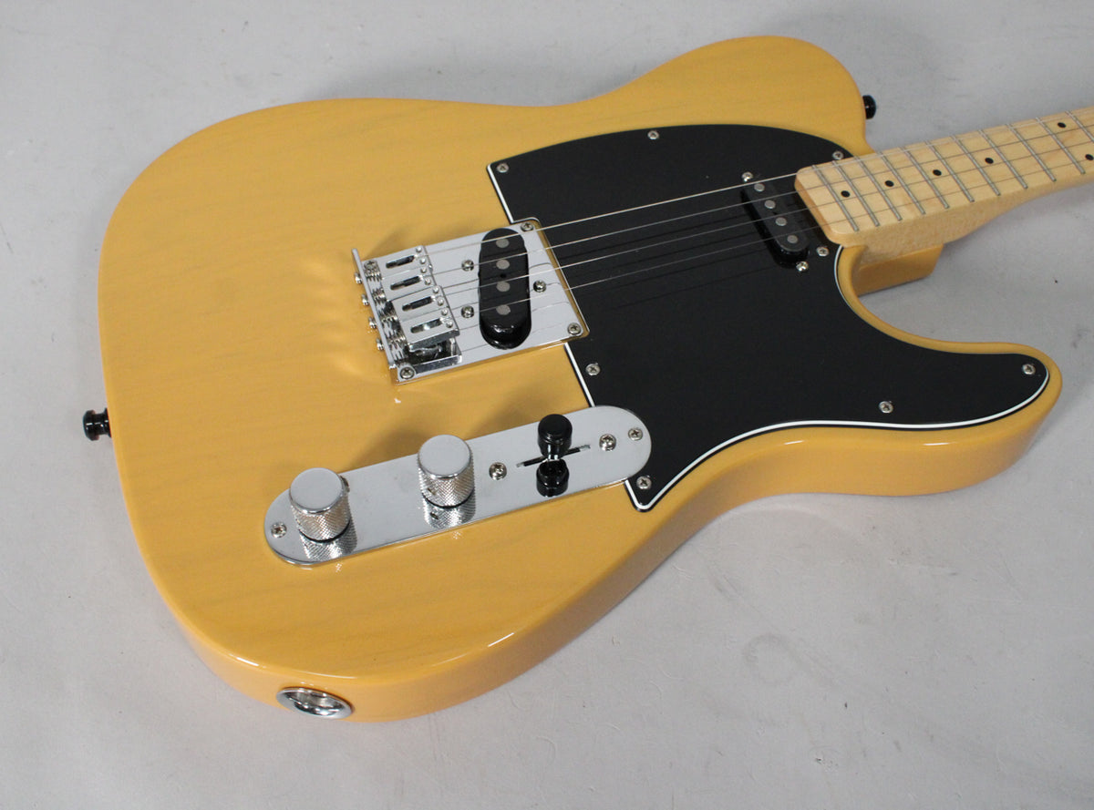The butterscotch blonde Telecaster body is angled from the lower right, showing its black pickguard, chrome bridge, and control plate.