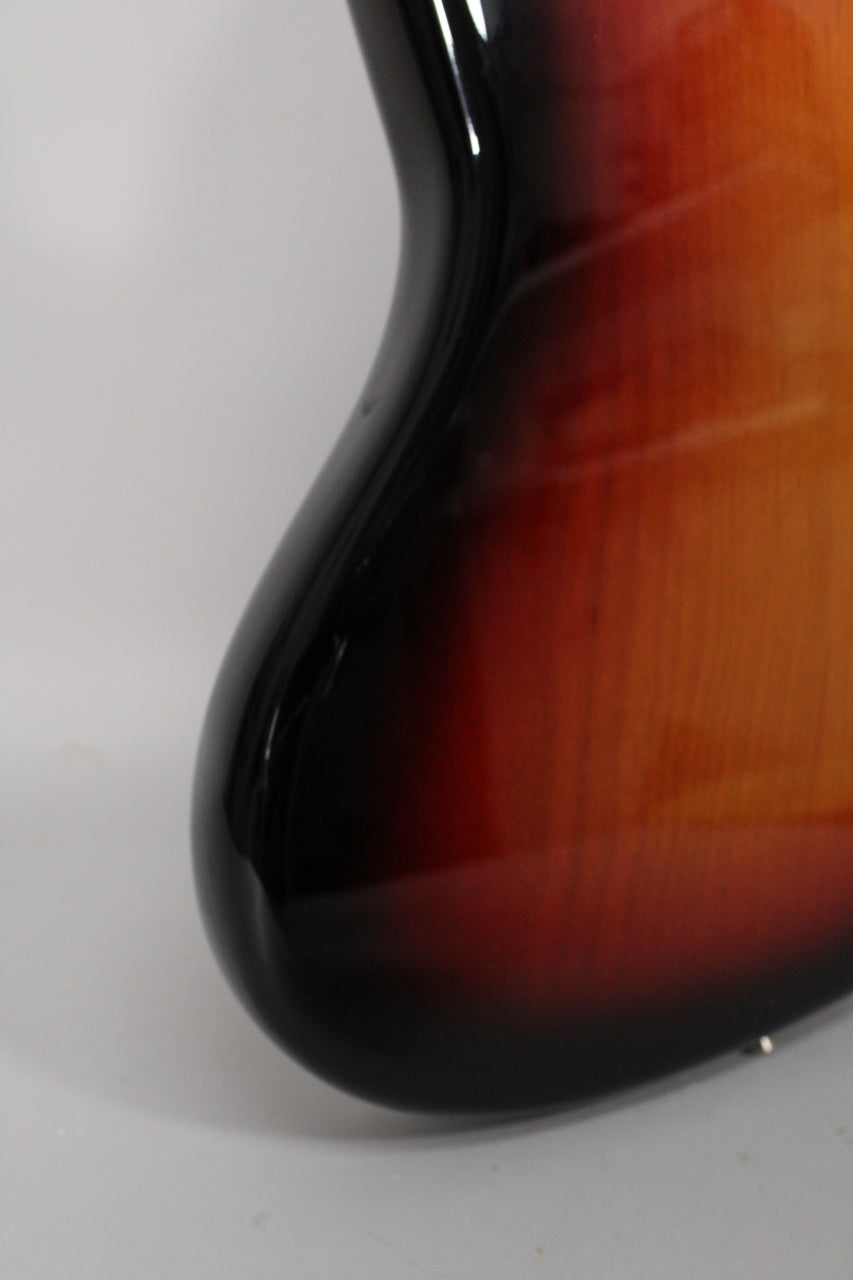 Close-up of the lower bout's curved edge, showing the glossy 3-color sunburst finish with a small chip on the black edge.