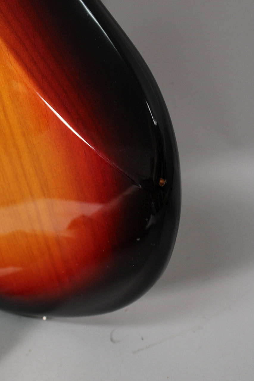 Close-up of the lower bout, showing the glossy 3-color sunburst finish with a visible chip and several light scratches.