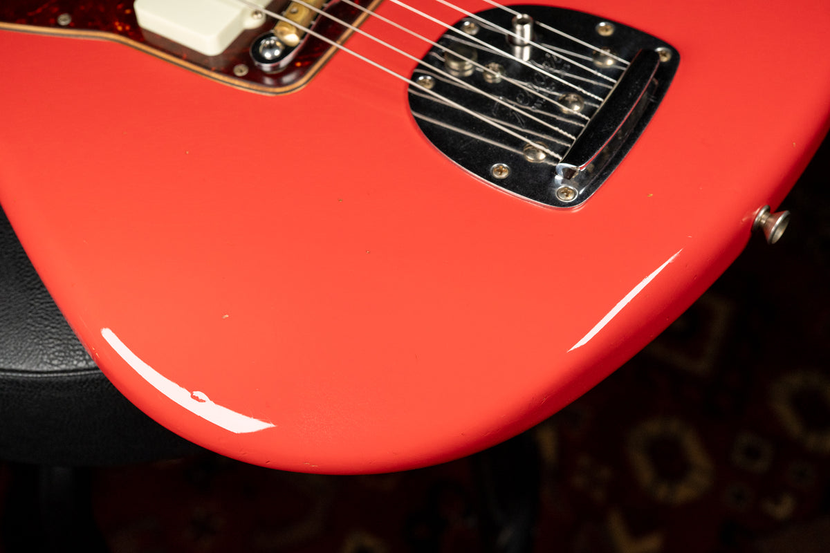 Close-up of the Fiesta Red body, showing the bridge, white pickup, tortoiseshell pickguard, and relic wear on the lower bout.