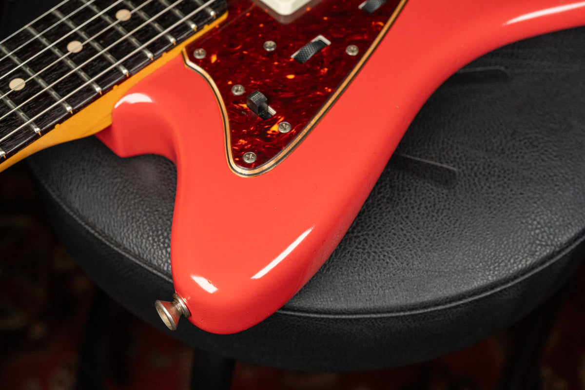 Close-up of the Fiesta Red body, showing the lower horn, output jack, and tortoiseshell pickguard with two black slider switches.