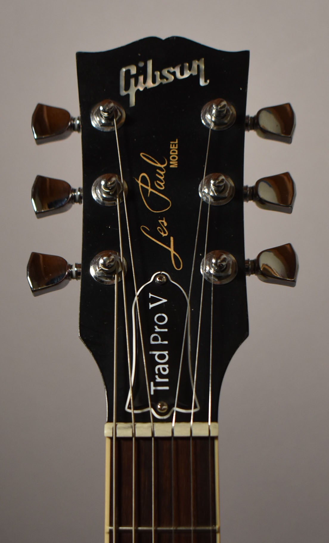 Close-up of the black headstock with chrome tuners, showing the top of the fretboard and nut.