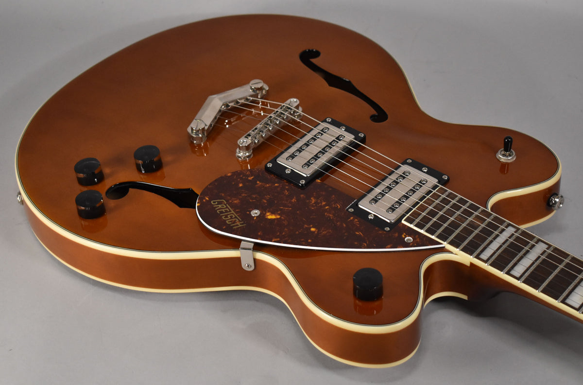 Sunburst semi-hollowbody electric guitar, angled from above, showing the upper bout, f-holes, dual humbuckers, and tortoise shell pickguard.