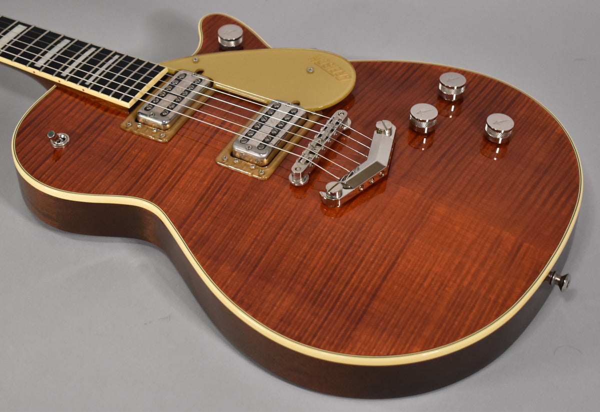The upper body of a flame maple Gretsch Jet BT in dark cherry, with a gold pickguard and chrome hardware.