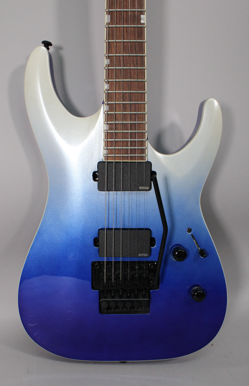 Full-frame view of a blue pearl fade metallic electric guitar with black hardware, two humbuckers, and a Floyd Rose tremolo.