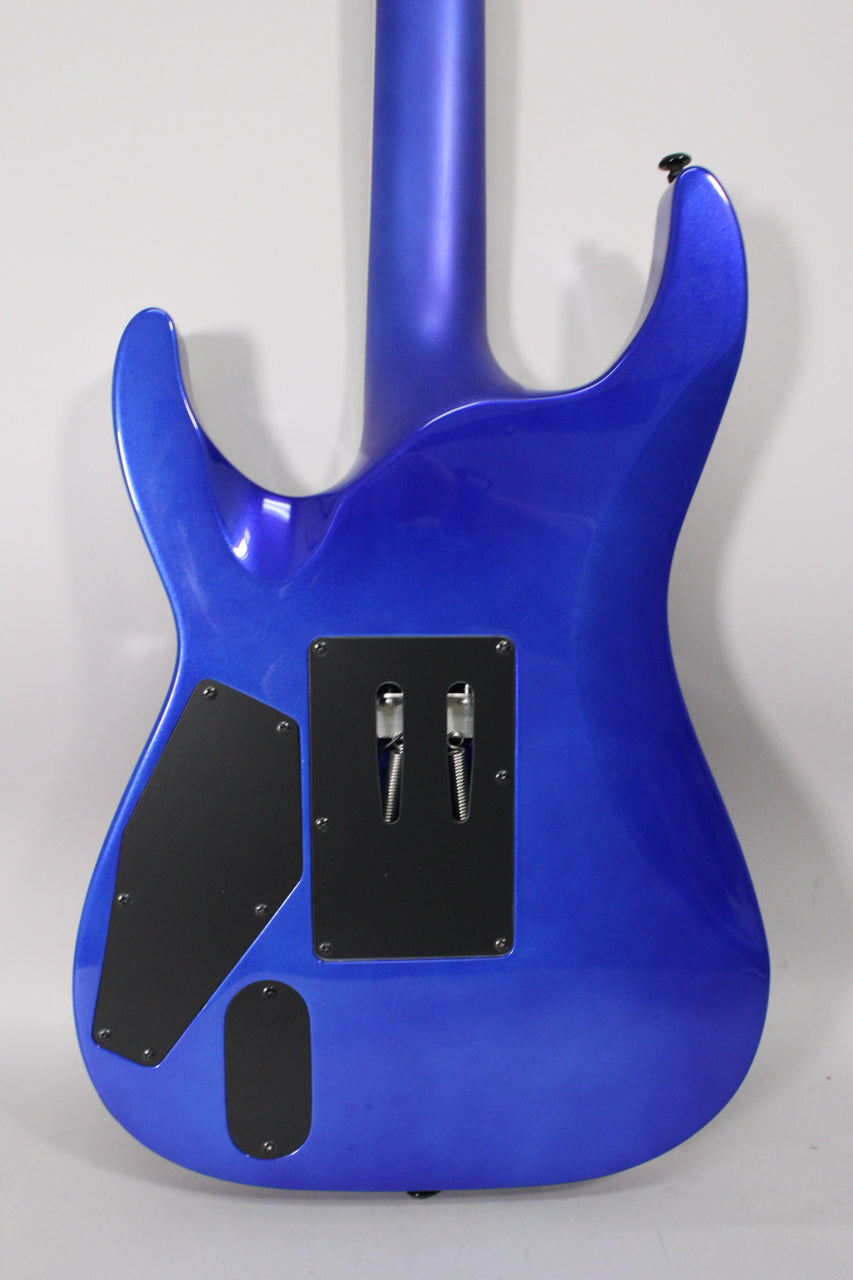 Back of a blue pearl fade metallic electric guitar, showing the neck joint, two black control plates, and tremolo springs.