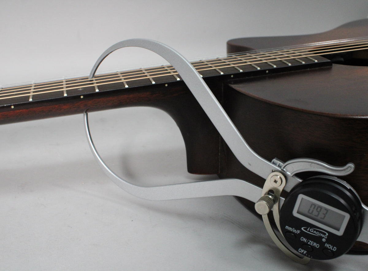 A digital caliper measures the dark brown neck at the 12th fret, showing a reading of 0.93.