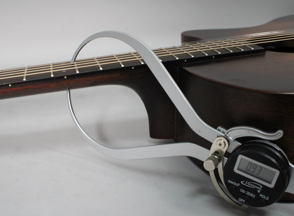 A digital caliper measures the dark brown neck at the 12th fret, showing a reading of 0.93.