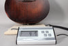 The dark brown acoustic guitar body rests on a cloth, with a digital scale displaying "4:7" in the foreground.