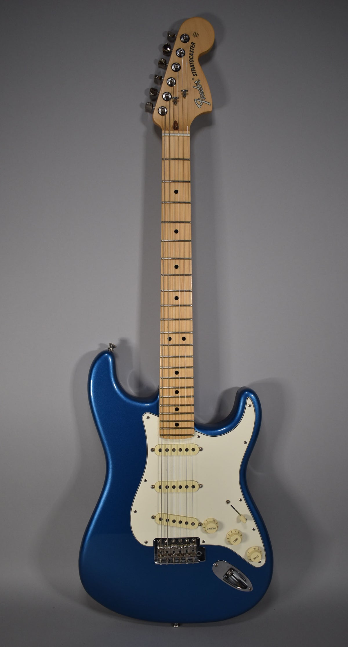 Full-length view of a blue satin Stratocaster with a maple neck, white pickguard, three single-coil pickups, and chrome hardware.