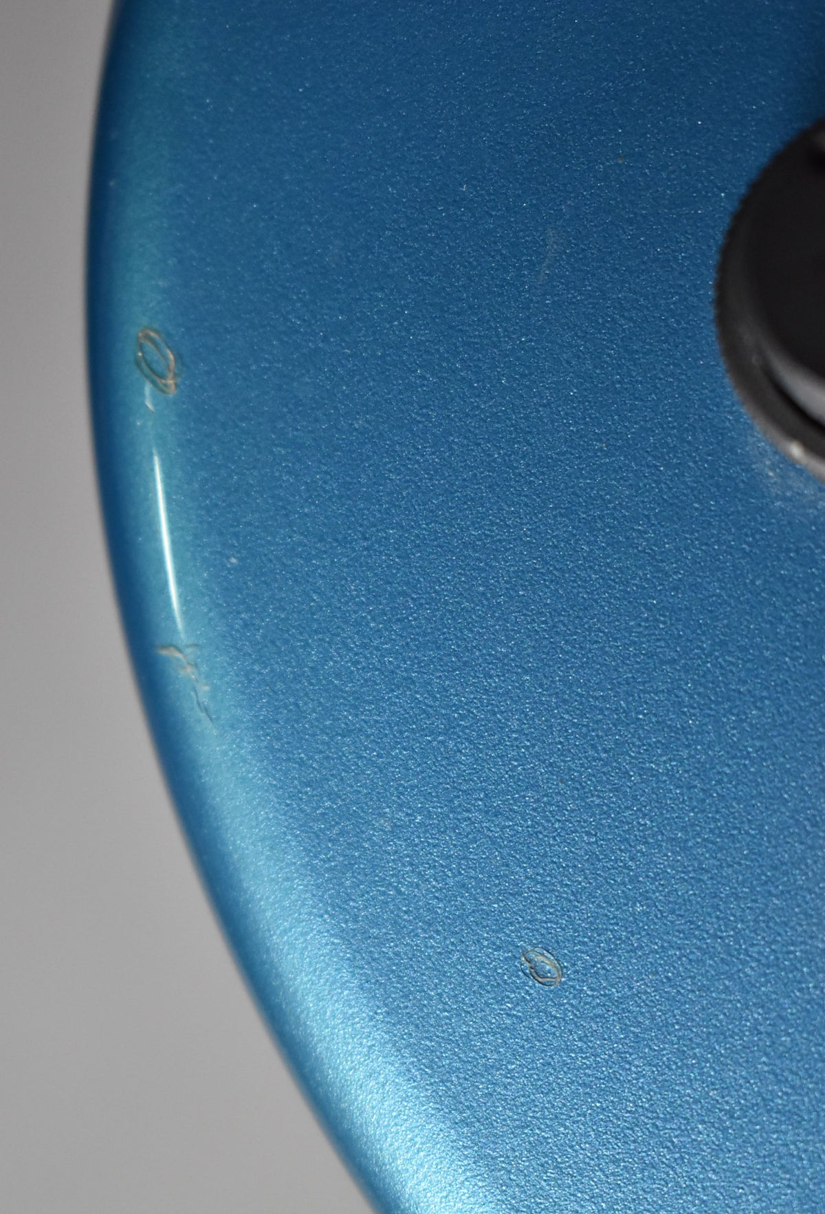 Close-up of the satin Lake Placid Blue body, showing a few small chips and scratches along the curved edge.