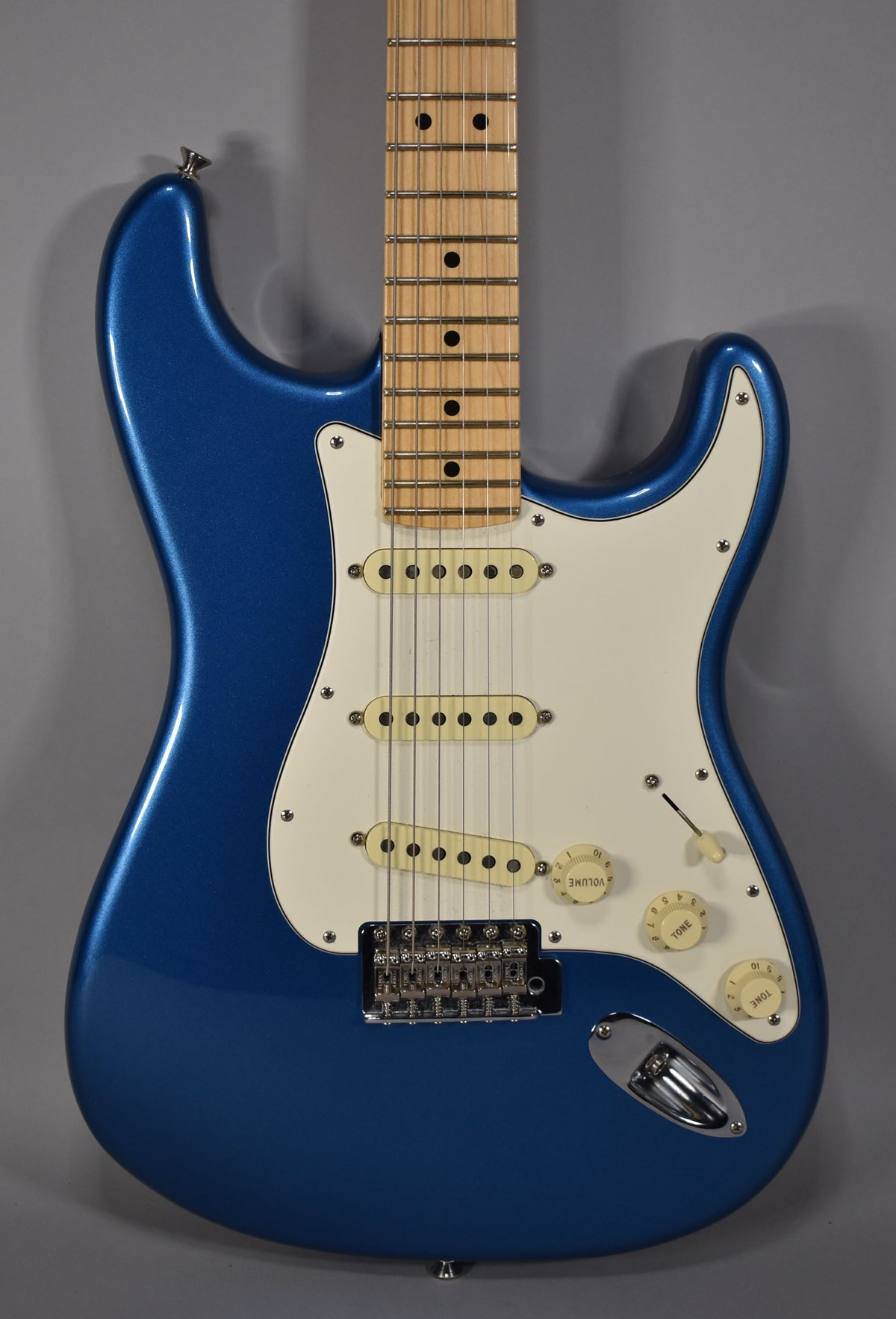 Full-frame, front view of a blue Stratocaster with a maple neck, white pickguard, three cream single-coil pickups, and chrome hardware.