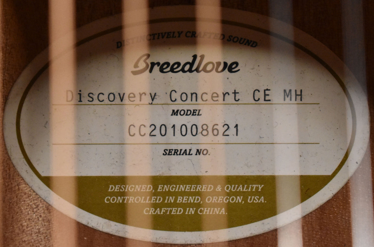 A close-up of the guitar's interior label, showing the model and serial number, with vertical shadows from the bracing.