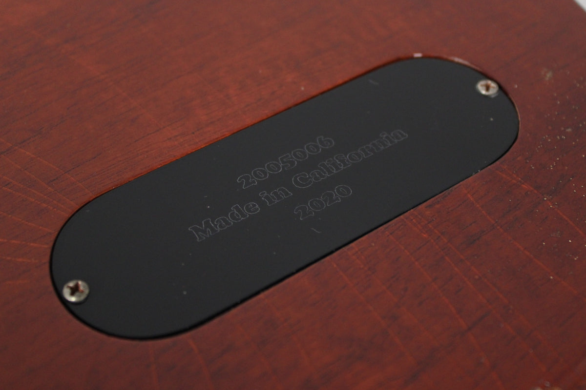 Close-up of the guitar's amber nitro finish, showing a black rectangular plate with "Made in California 2020" etched on it.