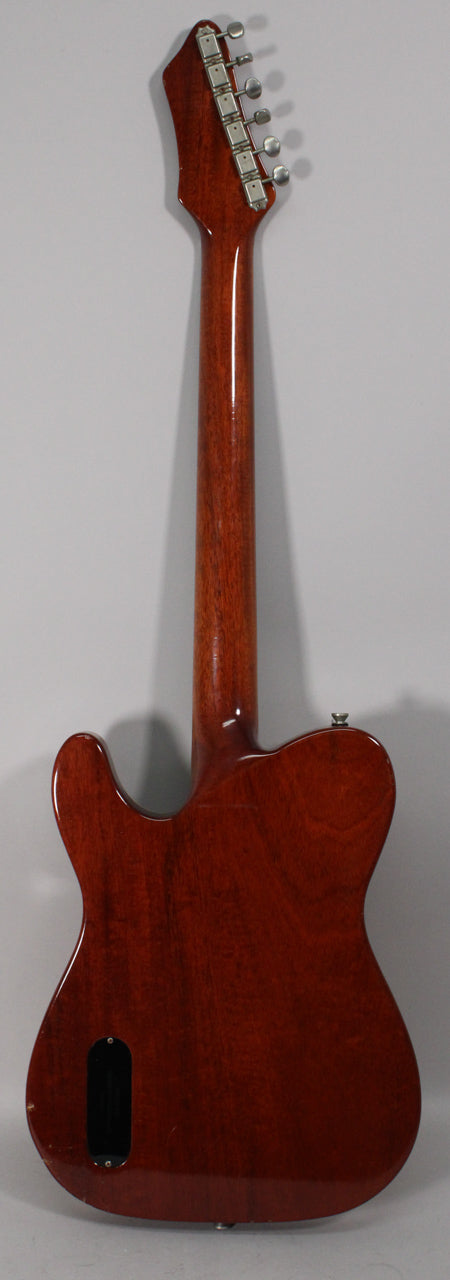 The full back of an amber nitro guitar with a black control cavity cover, showing light wear and checking.
