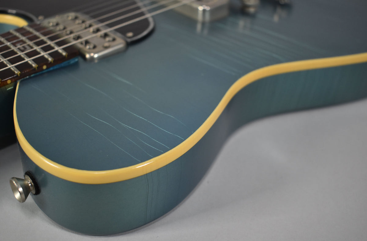 Close-up of the guitar's lower bout, showing the aged metallic Pelham Blue finish with visible checking and a cream binding.
