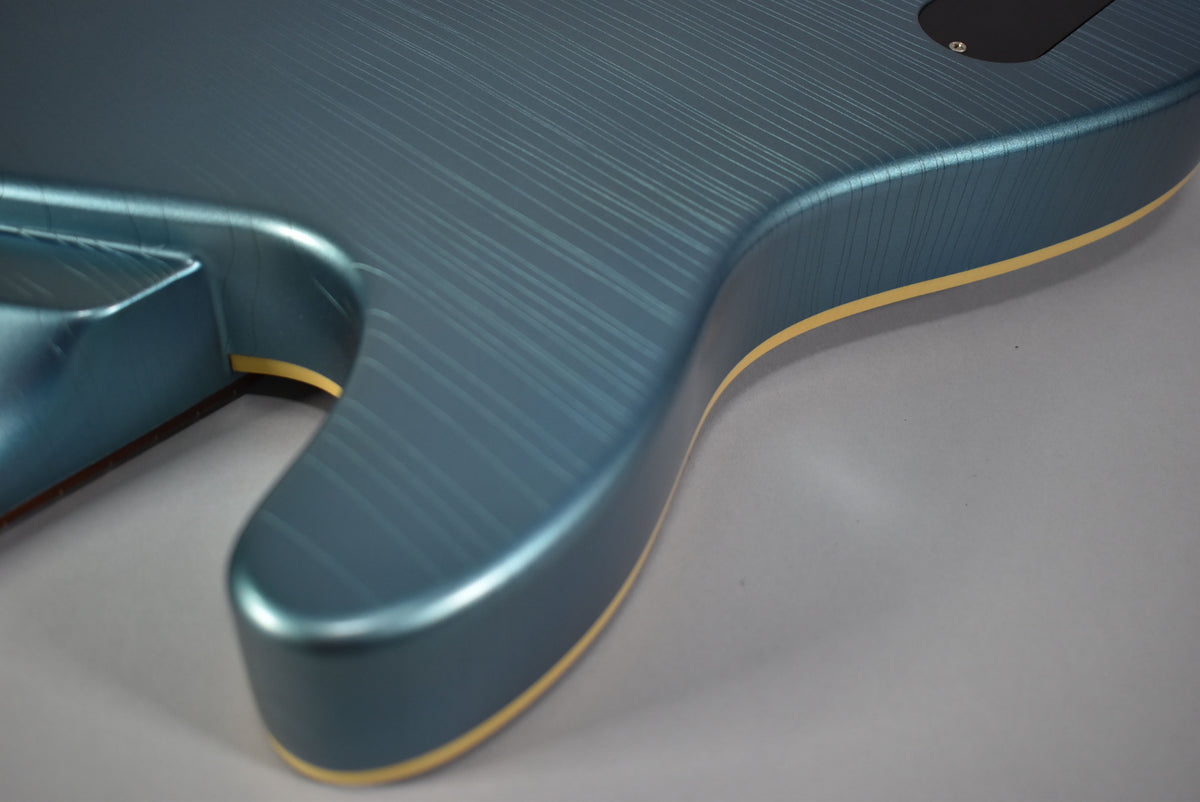 Close-up of the guitar's lower bout, showing the metallic Pelham blue finish with fine checking and cream binding.