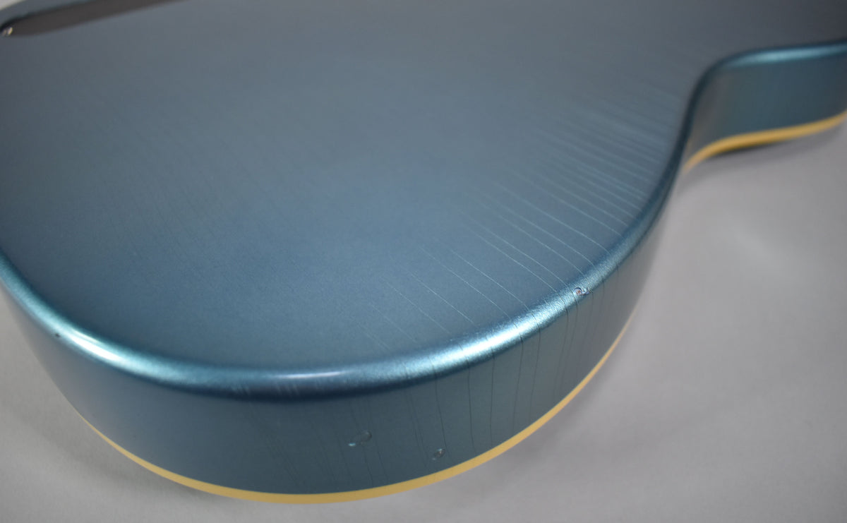 Close-up of the guitar's lower bout, showing the metallic Pelham Blue finish with extensive lacquer checking and a few small dings on the edge.