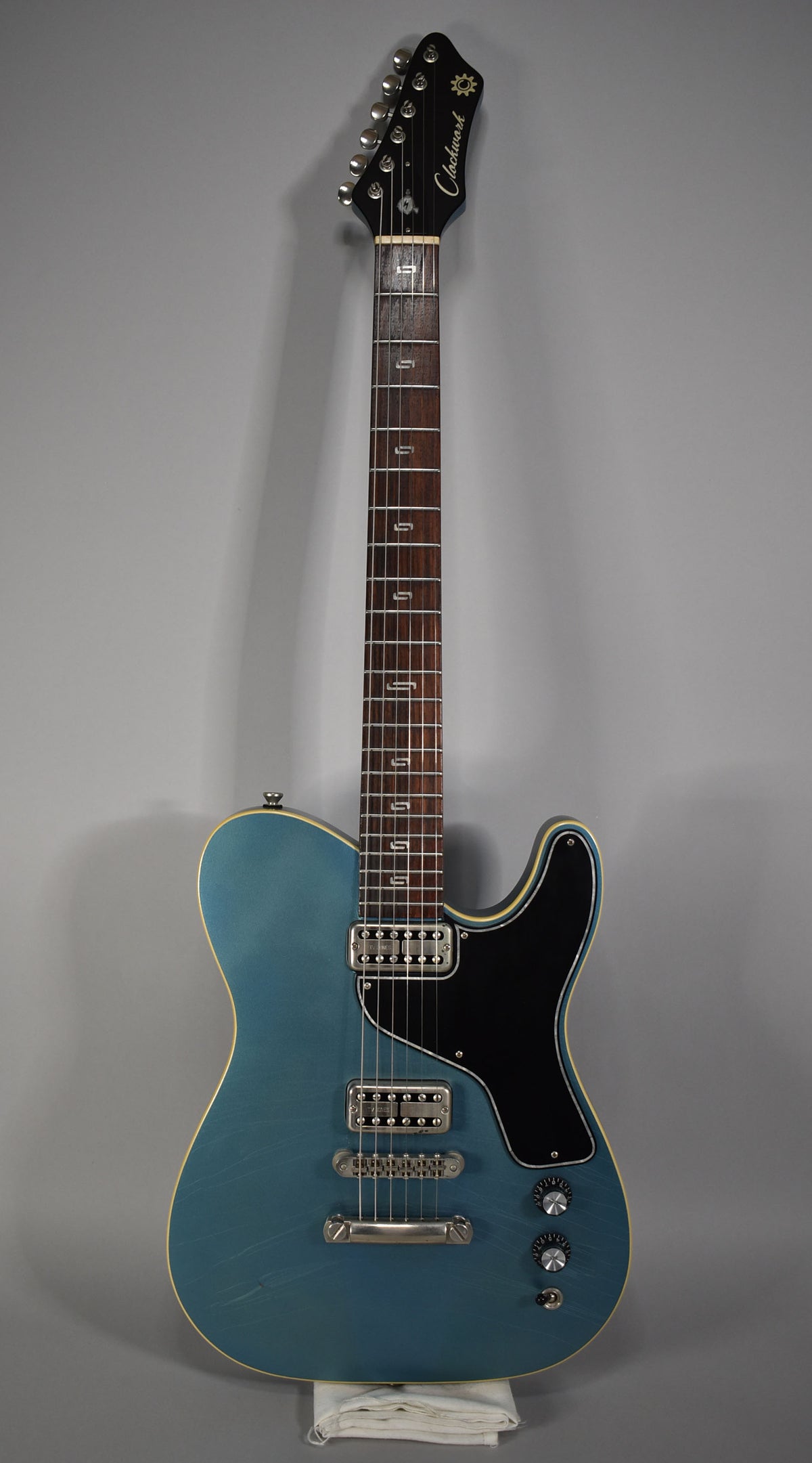 Full-length view of a metallic Pelham blue guitar with a black pickguard, two humbuckers, and aged hardware.
