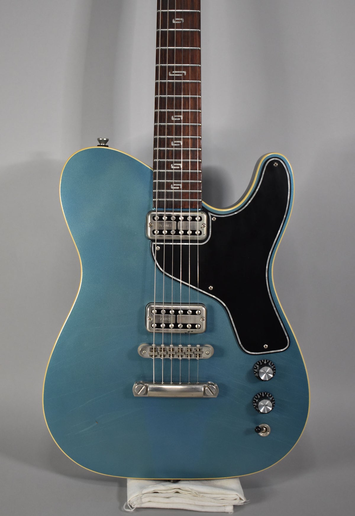 Metallic Pelham Blue guitar, body and neck visible, with two humbuckers, a black pickguard, and three knurled knobs.