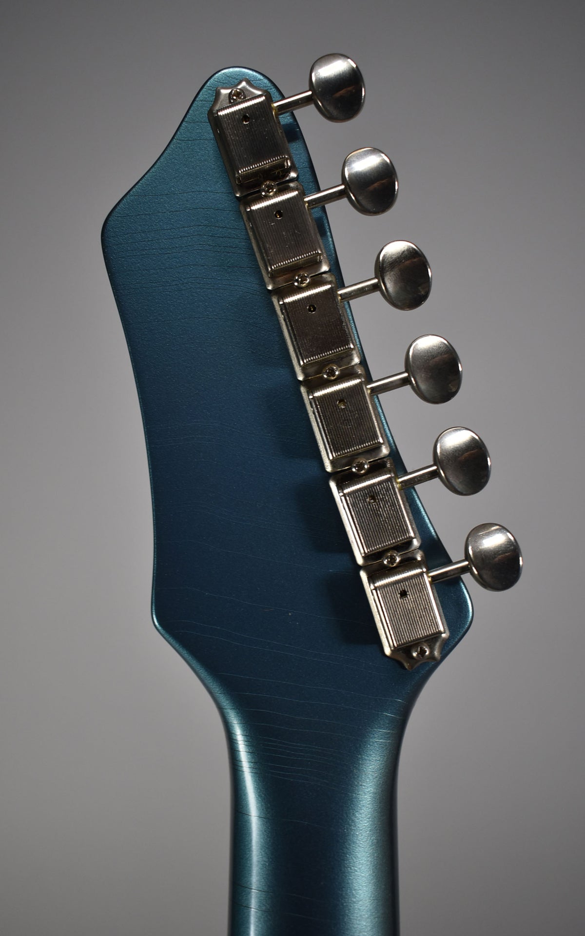 Rear view of the metallic Pelham Blue headstock and neck, showing six aged nickel tuners with oval buttons and fine finish checking.