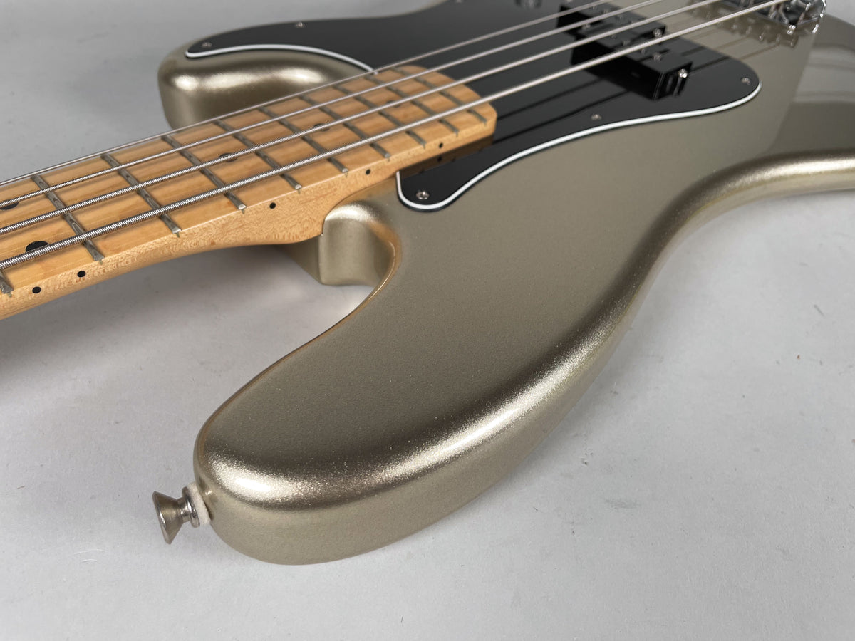 Close-up of the bass body from the lower bout, showing the metallic diamond finish, black pickguard, and maple fretboard.