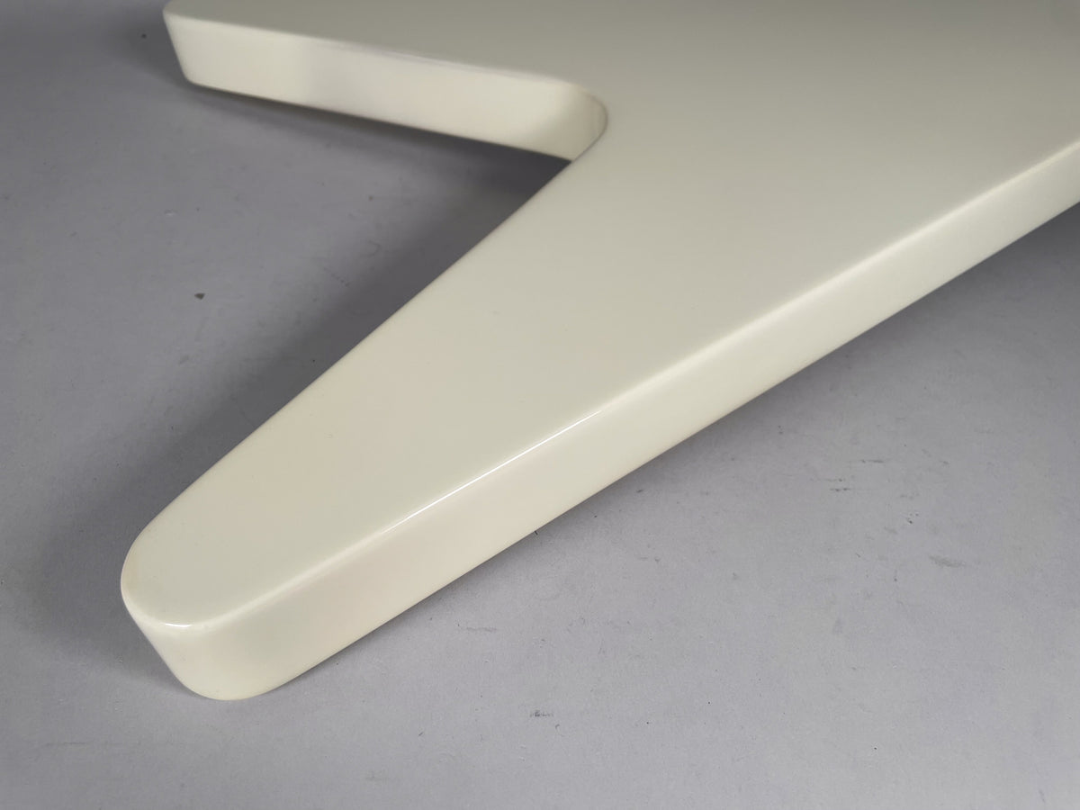 Close-up of the guitar's lower wing, showing the glossy white finish and a small chip on the rounded edge.