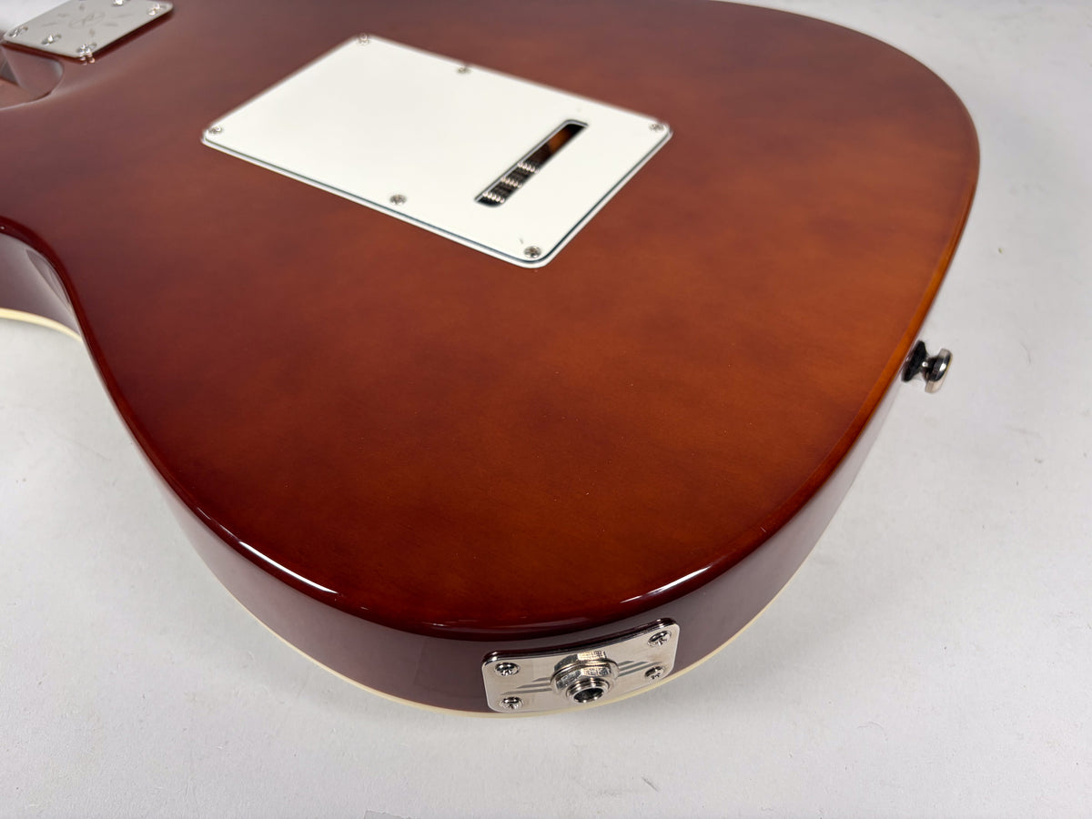 The guitar's sparkle brown back shows a white tremolo cover, a chrome output jack plate, and a chrome strap button.