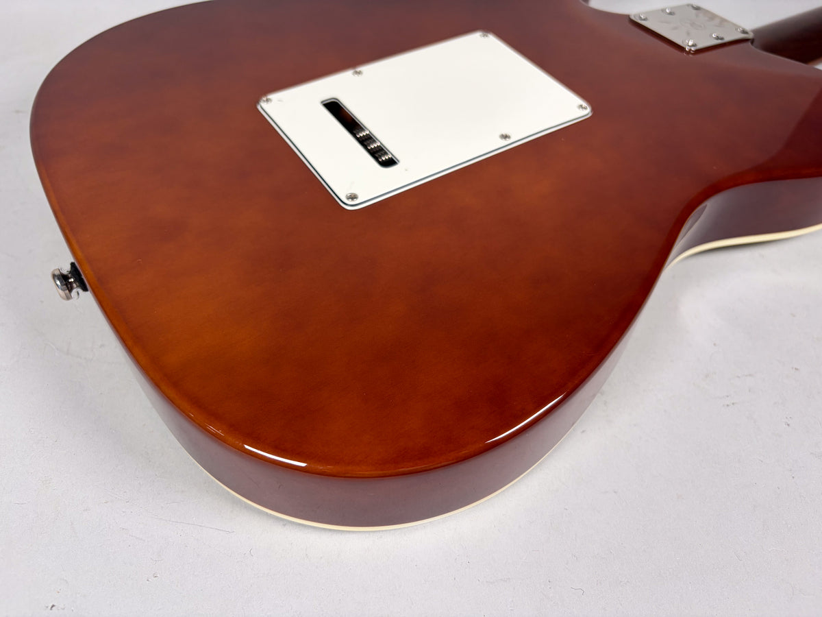 The guitar's glossy brown back shows a white tremolo cavity cover, a chrome neck plate, and a strap button.