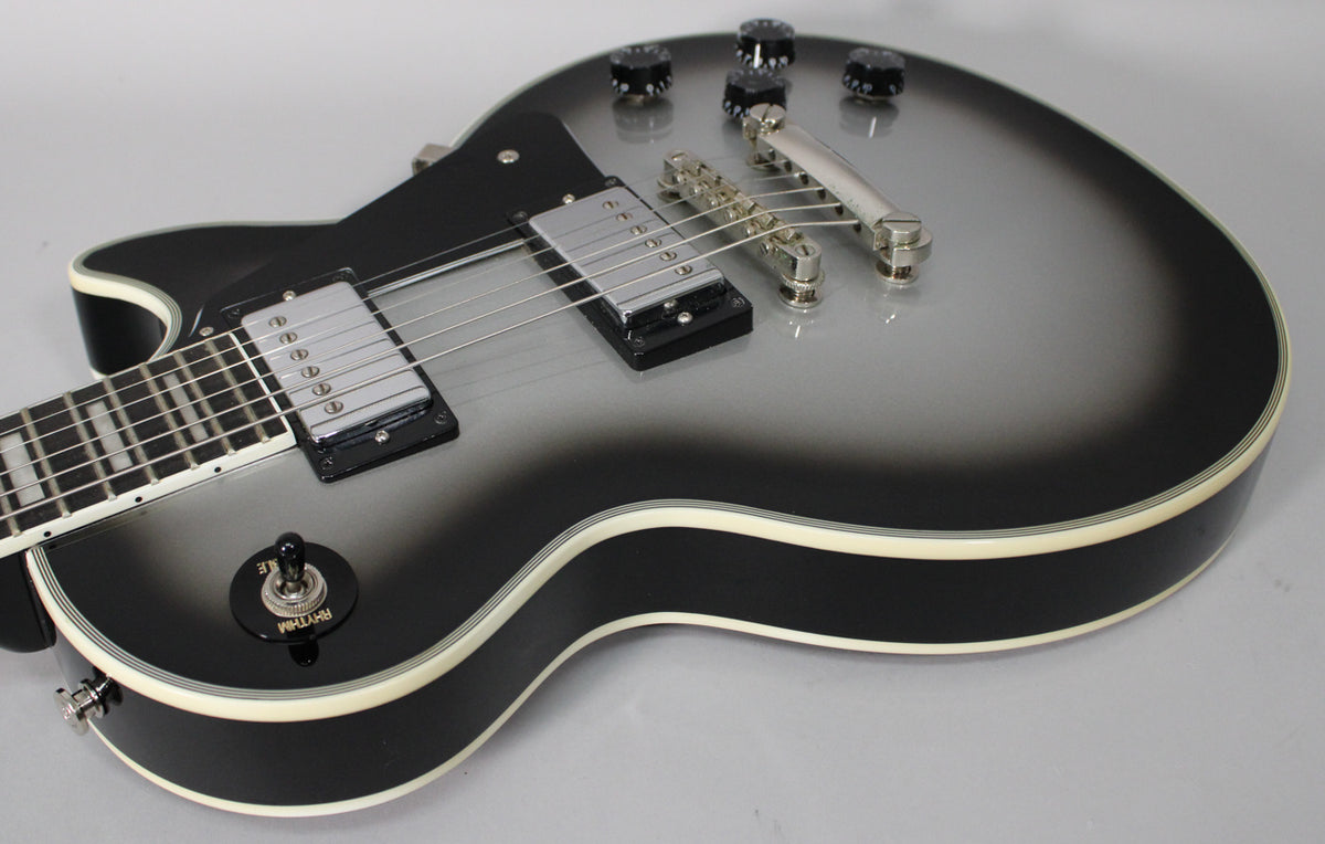 Close-up of the guitar's body, showing the silverburst finish, chrome hardware, black pickup rings, and cream binding with no visible wear.