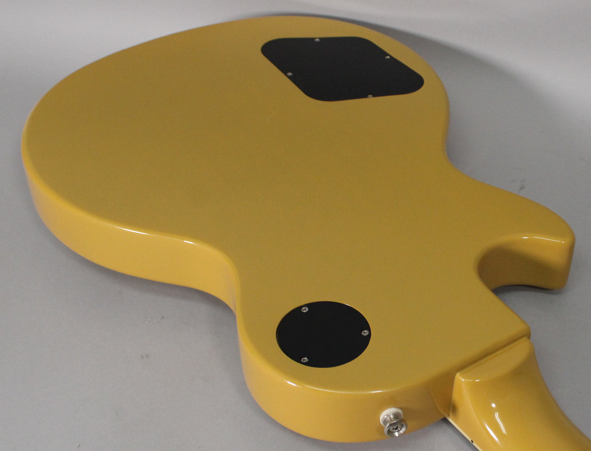 The back of a glossy TV Yellow guitar body, showing the control cavity and output jack, with a slight scuff near the lower horn.