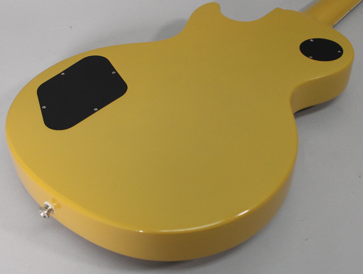 The back of a TV yellow guitar body, showing the control cavity and switch plate covers, and a chrome output jack.